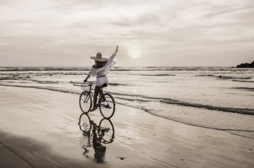 A woman riding a bike on the beach