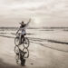 A woman riding a bike on the beach